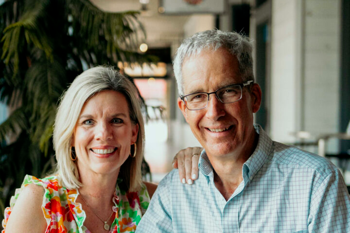 A man and woman smiling for the camera in a restaurant.