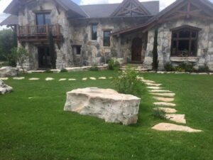 stone walkway to a modern house with a beautiful stone exterior