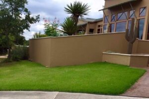 the backyard of a property with a retaining wall